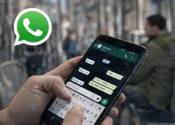 Smartphone con WhatsApp abierto mostrando un chat en transporte público y el logo de whatsapp destacado.