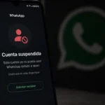 Pantalla de un teléfono celular Android mostrando una alerta de cuenta suspendida en WhatsApp con fondo oscuro.