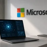 Computadora portátil sobre un escritorio con gráficos de ciberseguridad en la pantalla y el logotipo de Microsoft al fondo.